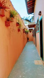 an alley with potted plants on the side of a building at Encanto Mada´s Itamambuca in Ubatuba