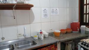 a kitchen with a sink and a counter with dishes at Encanto Mada´s Itamambuca in Ubatuba +12 photos