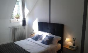 um quarto com uma cama com duas almofadas azuis em La Sauldre em Vailly-sur-Sauldre
