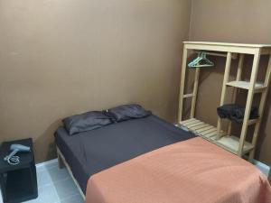 a small bedroom with a bed and a shelf at White apartment in Palenque
