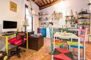 a kitchen with a table and a desk with a computer at Back Home in Pienza