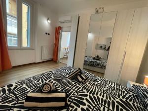 a bedroom with a black and white bed with a mirror at Casa Unzaja22 in Savona