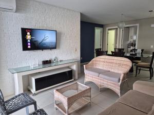 a living room with a tv on a wall at TerraMaris - Pé na Areia e Vista Mar Deslumbrante in Aquiraz