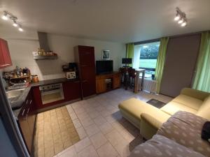 a living room with a couch and a kitchen at Ap76 Nature Ardennes Economy class apartment in La Calamine