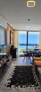 a living room with a table and a view of the ocean at Luxury Paiva Flat in Recife