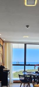 a dining room with a table and a large window at Luxury Paiva Flat in Recife