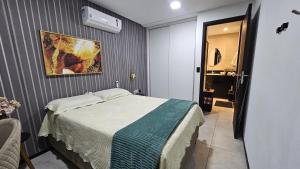 a bedroom with a bed and a painting on the wall at Luxury Paiva Flat in Recife