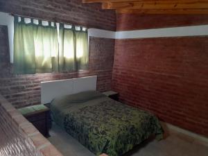 a bedroom with a bed and a brick wall at Terraza al Mar in Las Grutas