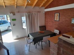 a dining room with a black table and chairs at Terraza al Mar in Las Grutas