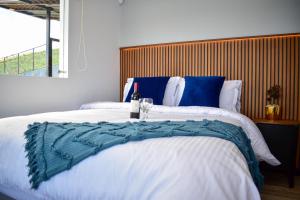 een slaapkamer met een groot bed en een fles wijn bij Alpez Chalet in Aquitania +55 foto's