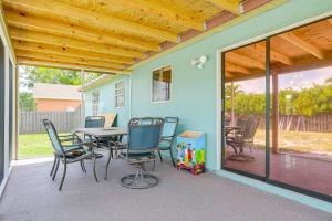 a patio with a table and chairs on a house at Mins to the Coast Port St Lucie Home with Lanai! in Fort Pierce