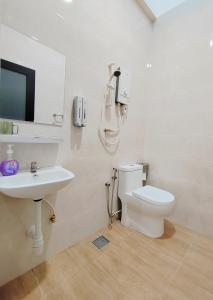 a white bathroom with a toilet and a sink at Green Homestay 3Br3Ba at Pinang in Kluang