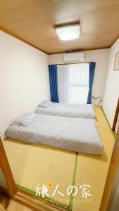 a bed in a small room with a window at 旅人の家 Entire貸切日式民宿 JR南柏駅 新柏駅 高速WiFi アメニティ完備 フルキッチン 洗濯機 上野駅30分 成田空港60分 in Kashiwa