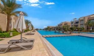 a pool at a resort with chairs and an umbrella at Luxury Stays in Mangroovy El Gouna in Hurghada