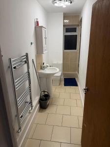 a bathroom with a sink and a toilet at Cosy 2 bedroom modern flat close to transport link in Gosport
