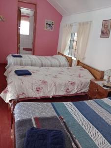 two beds in a bedroom with pink walls at casa de campo huancayo in San Antonio