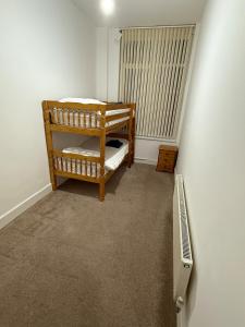 a room with two bunk beds and a radiator at Cosy 2 bedroom modern flat close to transport link in Gosport