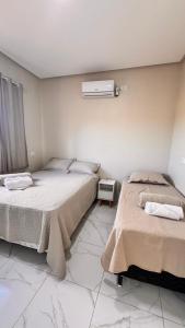 a bedroom with two beds and a heater on the wall at aconchego da serra in Coronel José Dias