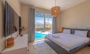 a bedroom with a bed and a swimming pool at Luxury Stays in Mangroovy El Gouna in Hurghada
