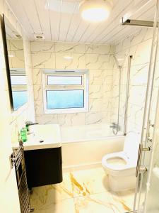 a bathroom with a sink and a toilet and a window at 224 Newcastle Street in Stoke on Trent