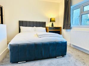 a bedroom with a large bed with a blue ottoman at 224 Newcastle Street in Stoke on Trent