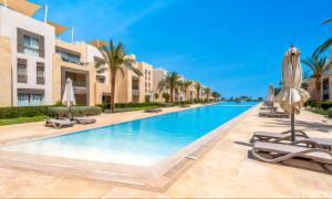 a swimming pool at a resort with lounge chairs and umbrellas at Luxury Stays in Mangroovy El Gouna in Hurghada +160 photos