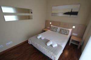 um pequeno quarto com uma cama com duas almofadas em ACP Cambrils Puerto Apartamentos em Cambrils