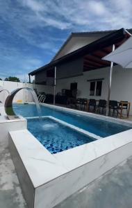 a pool with a water feature in front of a house at Tepi Villa Private Pool PD in Port Dickson