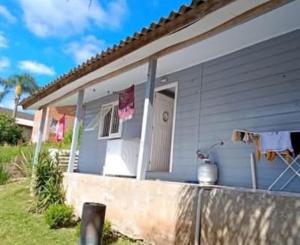 ein blaues Haus mit einer Veranda mit Wäscheleine in der Unterkunft House Tais in Gramado