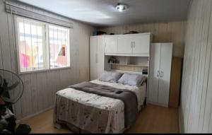 ein Schlafzimmer mit einem Bett und einem weißen Schrank in der Unterkunft House Tais in Gramado