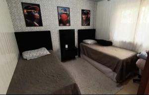 ein Schlafzimmer mit 2 Betten und Bildern an der Wand in der Unterkunft House Tais in Gramado