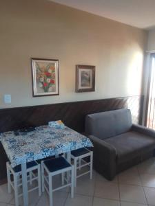 a living room with a table and a couch at Lola Apart in Bombinhas