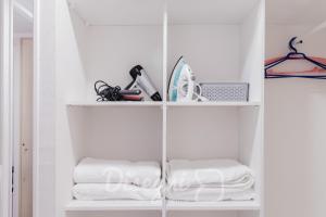 ein weißes Regal mit Handtüchern und anderen Gegenständen darauf in der Unterkunft Disegni 02 - Departamento Av del Mar La Serena Sector Casino Enjoy in Coquimbo + 16 Fotos