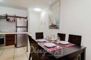 eine Küche mit einem Esstisch mit Gläsern darauf in der Unterkunft Disegni 02 - Departamento Av del Mar La Serena Sector Casino Enjoy in Coquimbo