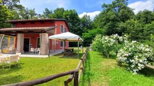 a red house with a garden and a fence at Foresteria dell'Oasi in Morozzo