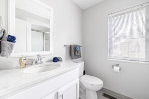 a white bathroom with a sink and a toilet at Luxury Downtown Townhome Private Garage Unit 11 in Cleveland +30 photos
