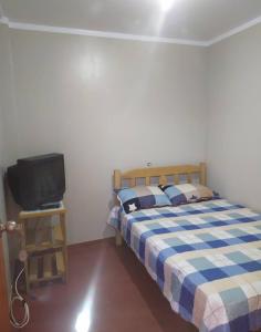 a bedroom with a bed and a small television at Piratex alojamiento in Huarmey