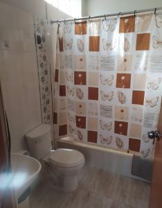 a bathroom with a toilet and a shower curtain at Piratex alojamiento in Huarmey