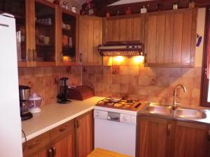 a kitchen with wooden cabinets and a white stove top oven at Maison Champagne in Escource
