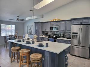 a kitchen with a large island with stools in it at Pelican Coast in Fort Myers