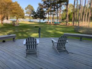 two chairs sitting on a wooden deck in a park at Two Oysters House in Saint Michaels