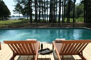 two chairs sitting next to a swimming pool at Two Oysters House in Saint Michaels