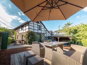 eine Terrasse mit Tisch und Stühlen und einem Sonnenschirm in der Unterkunft House in Coo near Famous Waterfalls in Stavelot