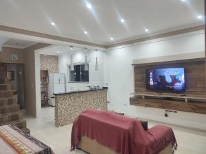 a living room with a tv on a wall at Cantinho Caiçara in São Sebastião