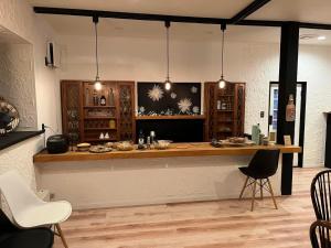 a kitchen with a counter and chairs in a room at The Bunkhouse Hakuba by Mr T in Hakuba