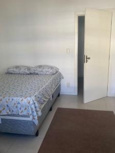 パリョサにあるQuarto Essencial com Conforto em casa compartilhadaのベッドルーム1室(ベッド1台、ドア、ラグ付)