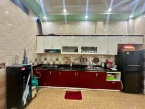 a kitchen with white cabinets and a black refrigerator at Ớt Family - 128 Cái Bèo - Homestay Cat Ba in Cat Ba