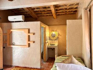 a small room with a bed and a desk at Serenity Lodge Zagora Guest House Restaurant & Desert Excursions in Zagora