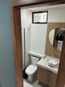 イポジュカにあるOra Beach Residenceのトイレ、洗面台、鏡を備えたバスルーム