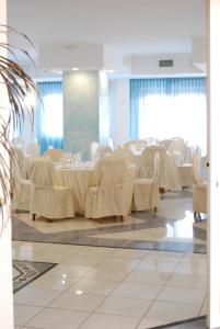 a banquet hall with white tables and white chairs at Dakar Living Hotel Vasto in Vasto